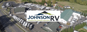 Johnson RV lot blurred in background with Johnson RV logo in focus in front.